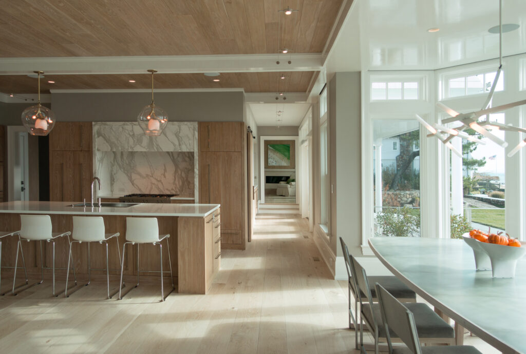 Modern open concept kitchen with bay window dining table on the water