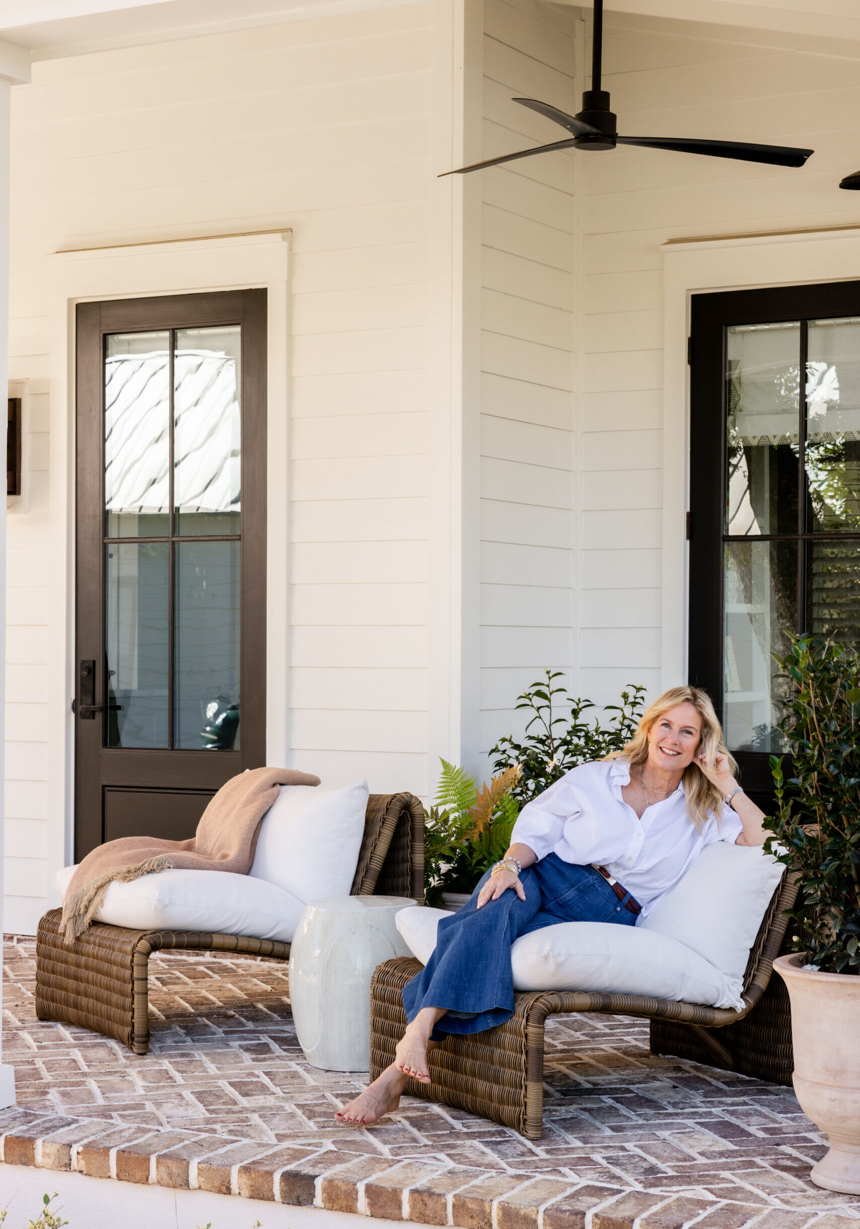 Amy sitting on a chair on a patio