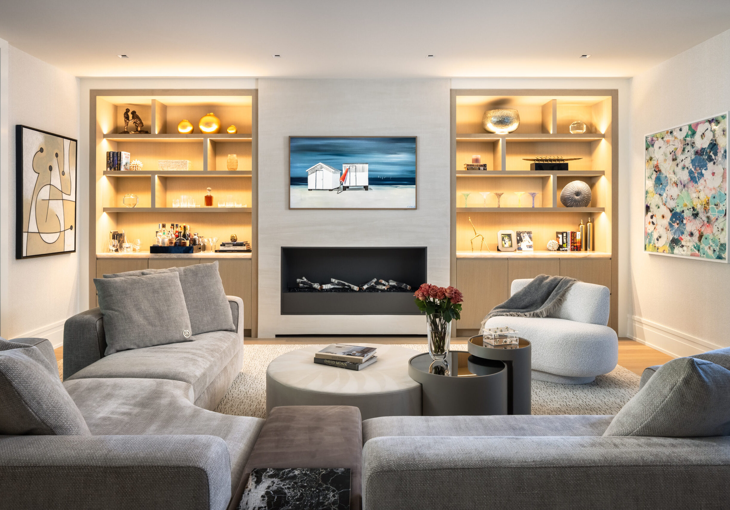 Living room with custom illuminated built-ins, linear fireplace, and curated artwork.